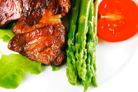 roasted beef meat served with asparagus on plateの写真素材