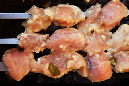 grilled and raw chicken shish kebab cooked on barbecue applianceの写真素材