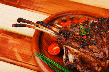 grilled ribs on wooden table with vegetables