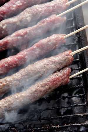 chicken shish kebab on bbq grill in sauce on skewers with tomatoes and peppers