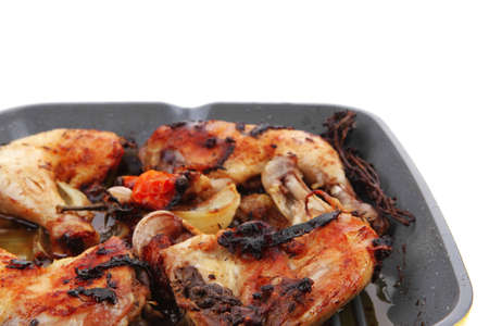 grilled chicken legs with tomatoes and thyme cooked on yellow ceramic pan isolated on white backgroundの写真素材