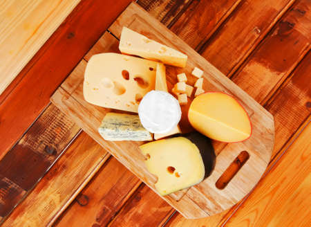 many delicious aged cheeses on wooden plateの写真素材