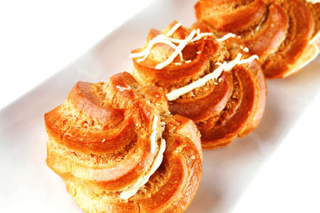 yummy eclairs with cream served over whiteの写真素材