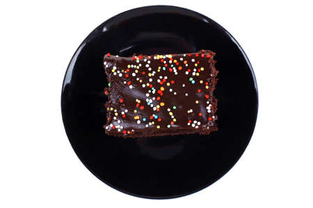 sweet food : chocolate cake coated with chocolate on black saucer isolated over white backgroundの写真素材