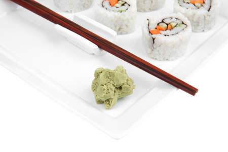 Maki Sushi - California Maki Roll made of fresh raw Salmon, Cream Cheese and Avocado inside. Served with wasabi . Isolated over white background on square plate