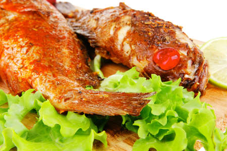 roasted sea fish on wood with tomatoes, lemon and salad