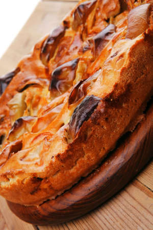 sweet round apple pie served on wooden table