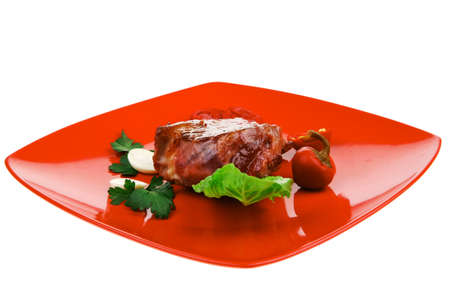 barbecued meat : beef ( lamb ) garnished with green lettuce and red chili hot pepper on red plate isolated over white backgroundの写真素材