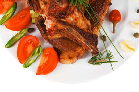 fresh grilled beef meat fillet on white plate with tomatoes and red pepper isolated  over white backgroundの写真素材