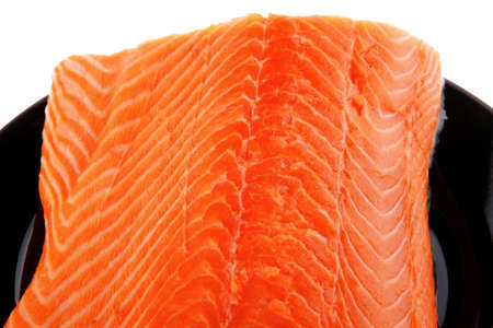 fresh uncooked red fish fillet on black over whiteの写真素材