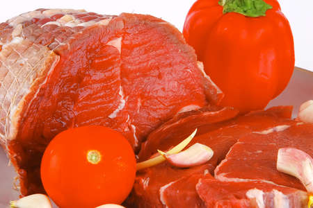bloody meat with tomato on dish close up