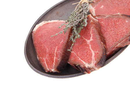 fresh raw red meat with thyme on metal pan isolated on white backgroundの写真素材