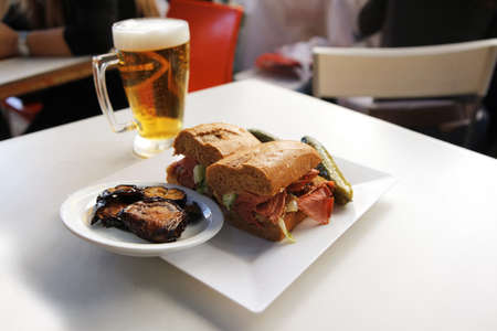 light beer and sandwich with beef and pork salami with snake on white tableの写真素材