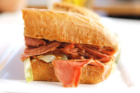 light beer and sandwich with beef and pork salami with snake on white tableの写真素材