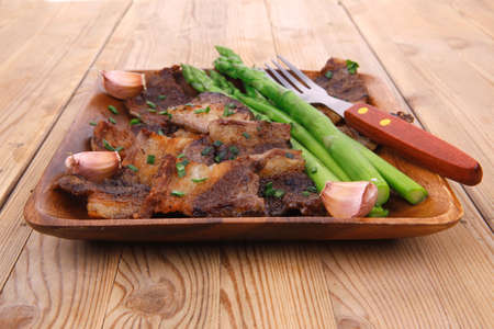 dinner of hot beef pork meat grilled ribs with asparagus and garlic over wooden background tableの写真素材