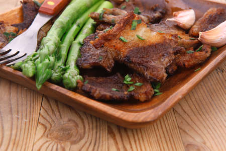 beef pork meat grilled ribs with asparagus and garlic over wooden background tableの写真素材