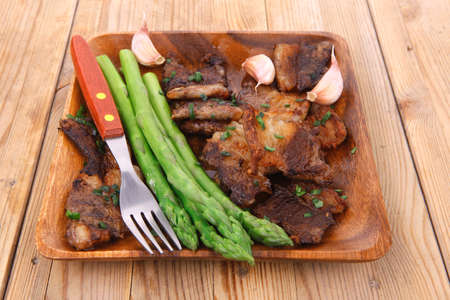 dinner of hot beef pork meat grilled ribs with asparagus and garlic over wooden background tableの写真素材