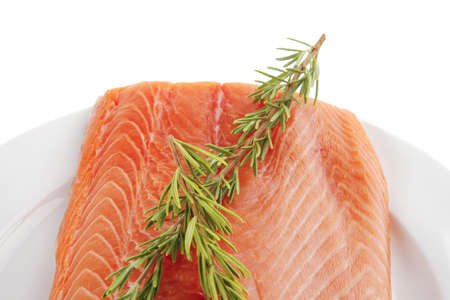 fresh raw red fish fillet on white plate and rosemaryの写真素材