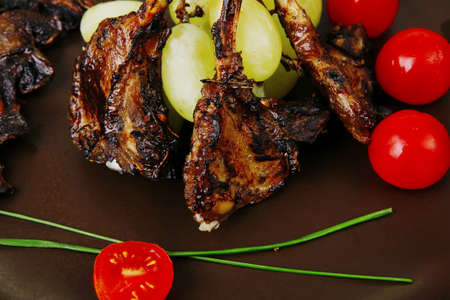 ribs on dish over wooden table with cherryの写真素材