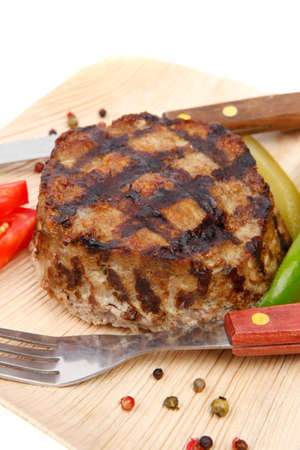 extra thick hot beef meat hamburger lunch on light wooden plate with tomatoes salad and cutlery...