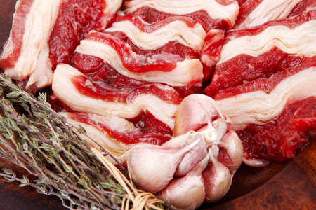 raw ribs with thyme and garlic on wooden isolated over white backgroundの写真素材