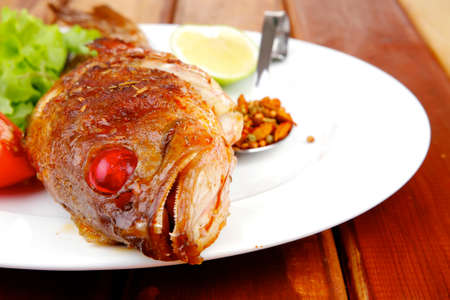 savory on wood: fried fish served with tomatoes lemon and spicesの写真素材