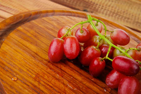 fresh raw red grape on wooden table