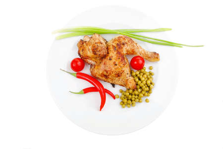 meat food : roast chicken garnished with green onion and red chili hot pepper on white plate isolated over white backgroundの写真素材