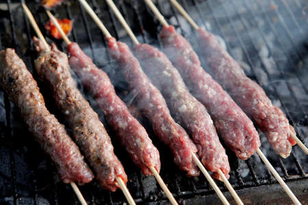 chicken shish kebab on bbq grill in sauce on skewers with tomatoes and peppers
