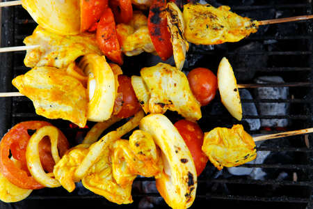fresh raw roast shish kebab on barbecue grill grid coocked over hot charcoal