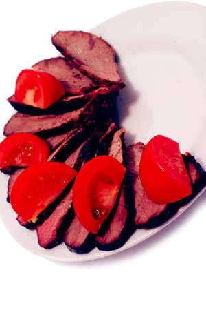grilled beef meat steak with fried potatoes and tomatoes on white plate isoalted over whiteの写真素材