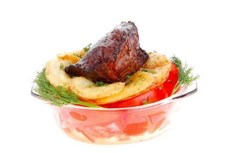 fresh roast beef meat chunk in transparent bowl over baked potatoes and tomatoves served with fill isolated over white backgroundの写真素材