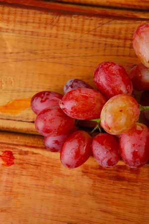 fresh raw red grape on wooden tableの写真素材
