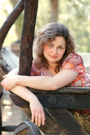 young white happy caucasian girl enjoy in countrside on old wood builtsの写真素材