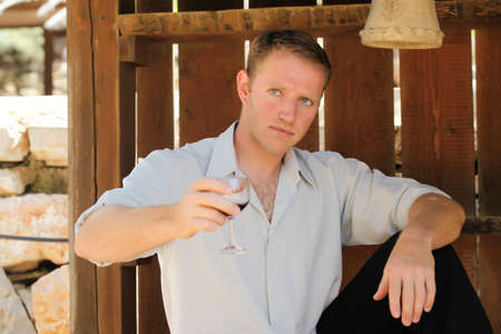 young happy white caucasion man taste and enjoy red wine outdoor in in countryside . classic style...