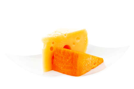fresh dairy product : gourmet cheese triangles of yellow parmesan and orange cheddar on a plate...