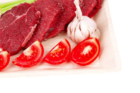 fresh raw beef meat steak fillet on wooden plate with asparagus and tomatoes ready to prepare isolated over white backgroundの写真素材