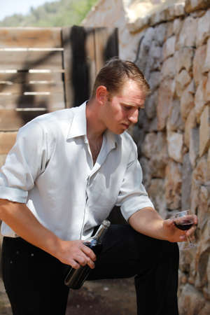 young happy white caucasion man taste and enjoy red wine outdoor in in countryside . classic style...