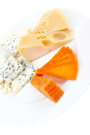 fresh aged french cheese parmesan roquefort and gruyere chops with slices on plate with isolated over white backgroundの写真素材