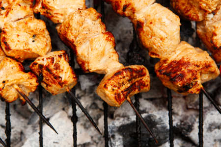 fresh hot grilled chicken shish kebab barbecue on grid over charcoal