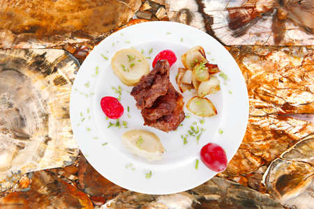 beef bourguignon in wine with artichoke and marinated vegetables on white plate isolated over white backgroundの写真素材