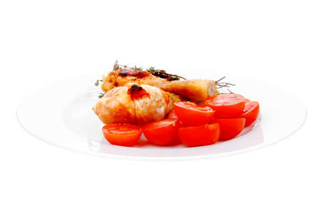 grilled chicken drumstick with tomatoes and thyme on white plate isolated over white backgroundの写真素材
