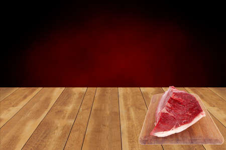 fresh raw red beef meat big steak chunk on wooden cut board isolated over white backgroundの写真素材
