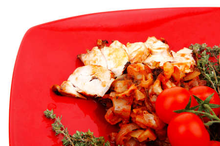 meat grilled chicken fillet with salad and tomatoes on red plate isolated over white backgroundの写真素材
