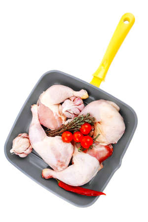raw chicken legs with tomatoes and thyme on yellow ceramic pan ready to cooking isolated on white backgroundの写真素材