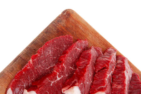 fresh raw beef meat steak slices on wooden cut board isolated over white backgroundの写真素材