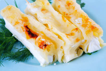cannelloni in yellow cheese served with greeneryの写真素材