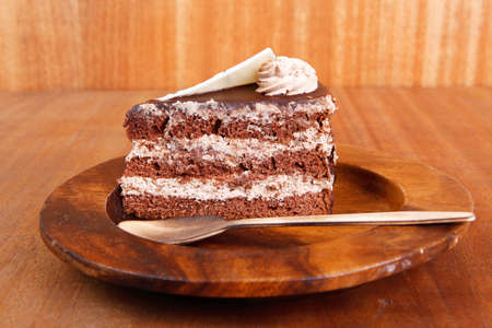 sweet brownie chocolate cream cake topped with white chocolate and cream with chocolate with...