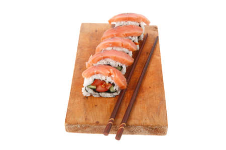 classic onigiri inside out californian sushi rolls with salmon on wooden plate isolated over white background with sticksの写真素材