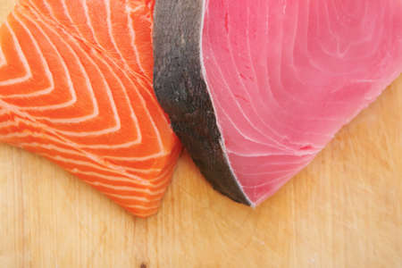 pieces of salmon and tuna fish on wooden plateの写真素材